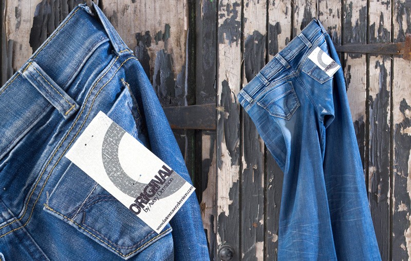 Plastic Staple System tag attached to hanging pair of jeans